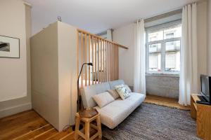 a living room with a couch and a staircase at Pretty 163 in Porto