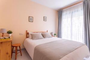 une chambre avec un grand lit blanc et une fenêtre dans l'établissement Bonaire, à L'Escala