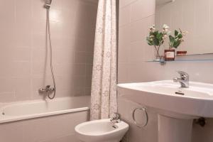 une salle de bain avec un lavabo, des toilettes et une baignoire dans l'établissement Bonaire, à L'Escala 7 autres photos