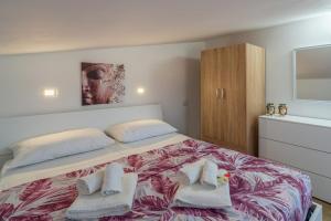 1 dormitorio con 1 cama grande y toallas. en Appartamento Sud in Villa Sele, en Fontane Bianche