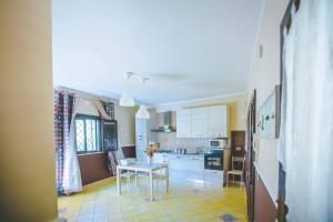 シラクーサにあるCasale Santuzza - Xenia Sicily Villasの白いキャビネットとテーブル付きのキッチンが備わります。