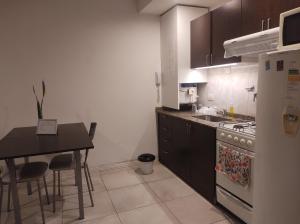 a kitchen with a stove and a table and a refrigerator at Temporarios Sanatorios CENTRO in Rosario +4 photos