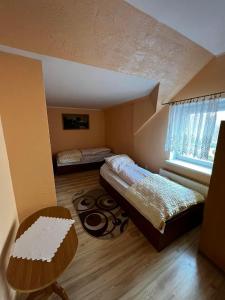 a bedroom with a bed and a table and a window at Motel Za Grosik in Wałcz