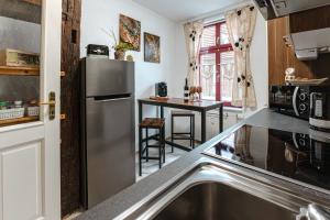 a kitchen with a stainless steel refrigerator and a table at Naumburger Charme "Schwarzes Gold" in Naumburg