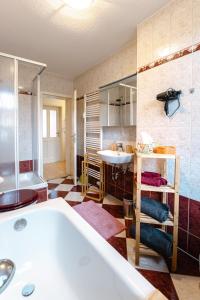 ein Badezimmer mit einer Badewanne und einem Waschbecken in der Unterkunft Naumburger Charme "Schwarzes Gold" in Naumburg