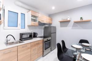 een keuken met een wastafel en een tafel met stoelen bij elegant escapes 2 nea smyrni in Athene +4 foto's