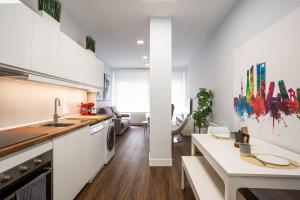 a kitchen with white cabinets and a counter top at Apt nuevo! 2 hab, baño doble, garaje, Metro a 200m in Madrid