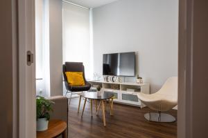 a living room with a tv and a table and chairs at Apt nuevo! 2 hab, baño doble, garaje, Metro a 200m in Madrid