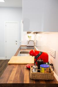 馬德里的住宿－Apt nuevo! 2 hab, baño doble, garaje, Metro a 200m，木桌上配有红色用具的厨房