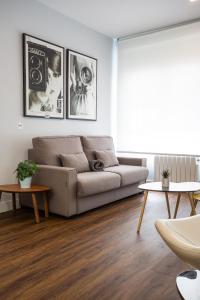 Una sala de estar con un sofá y dos mesas. en Apt nuevo! 2 hab, baño doble, garaje, Metro a 200m, en Madrid