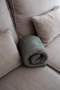 una almohada marrón sentada en un sofá en Apt nuevo! 2 hab, baño doble, garaje, Metro a 200m, en Madrid