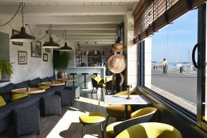 a restaurant with yellow chairs and tables and a window at Le Général d'Elbée Hotel & Spa - Teritoria in Noirmoutier-en-l'lle
