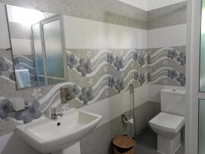 a bathroom with a sink and a toilet and a mirror at Ayubowan Homestay Katunayake in Katunayake