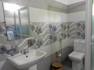 een badkamer met een wastafel, een toilet en een spiegel bij Ayubowan Homestay Katunayake in Katunayaka