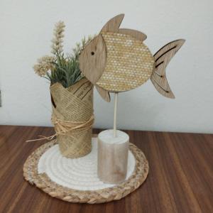 a wooden fish on a table with a vase of flowers at Guest House Oleandro IUN 2727 in Santa Maria Navarrese