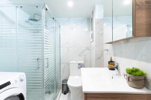 a bathroom with a toilet and a glass shower at Aiolos plateia apartment nea smyrni in Athens