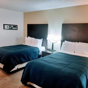 מיטה או מיטות בחדר ב-Nittany Budget Motel