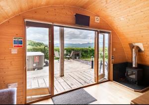 a room with a large glass door leading to a deck at 68 Degrees West Glamping in Brecon