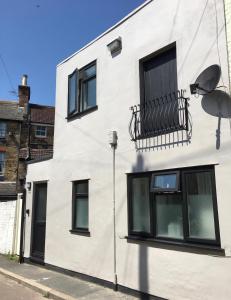 a white building with a balcony on the side of it at Shoemakers Cottage in Ramsgate