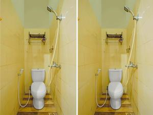two toilets in a bathroom with two sinks at OYO 92496 Faraas Homestay Syariah in Nongsa