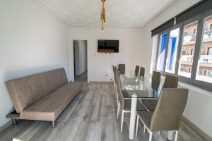 ein Wohnzimmer mit einem Sofa, einem Tisch und Stühlen in der Unterkunft COVESA III Centro Levante Beach in Benidorm