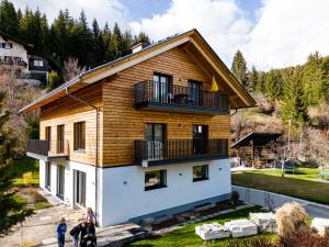 Ein Haus mit Leuten, die davor stehen. in der Unterkunft FeWo Sonnenschein in Weissbriach