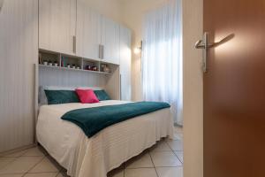 Schlafzimmer mit einem Bett mit grünen und rosa Kissen in der Unterkunft La Casa del Cortile by Wonderful Italy in Turin