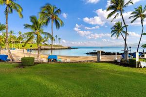 a view of a beach with palm trees and the ocean at Fairways at Mauna Lani #1703 in Kawailiula