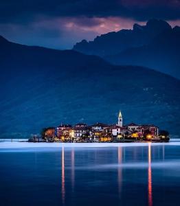 una ciudad en la orilla del agua por la noche en Giò's House vintage style, en Stresa
