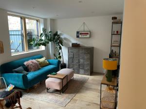 a living room with a blue couch and a table at Ideal Bristol getaway - 3 bed harbourside home in Bristol