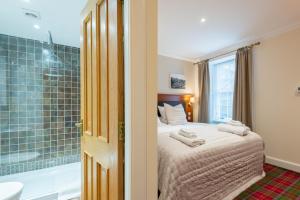 een slaapkamer met een bed, een bad en een douche bij 138 North Street - luxury 2 bed 2 bath with secret garden, summerhouse, putting green in St Andrews