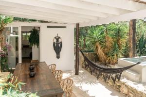 patio z drewnianym stołem i hamakiem w obiekcie Hotel Can Sastre w mieście Santa Gertrudis de Fruitera +37 zdjęć