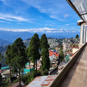 a view of a city from the balcony of a building at Darjeeling Heights - A Boutique Mountain View Homestay in Darjeeling