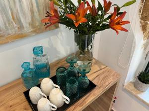 stół z niebieskimi szklanymi wazami i wazon z kwiatami w obiekcie Antica Canea Luxury Rooms w Chanii
