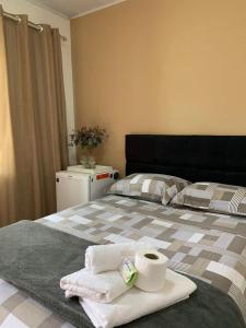 Una cama con toallas y una taza de café. en Suíte 101- Espaço Praia Aptos, en Angra dos Reis