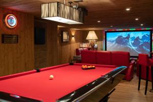 a room with a pool table and a tv at Le Chalet des Ours in Megève