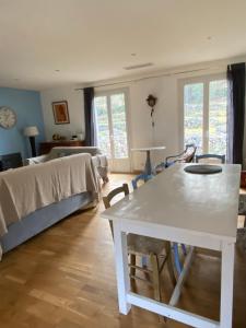 een woonkamer met een witte tafel en een bed bij Maison agréable et familliale in Roquefort-les-Pins