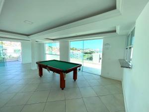 a pool table in a room with a large window at Luz do Sol até 10 Pessoas com Ar Condicionado in Arraial do Cabo