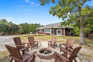 a group of chairs around a fire pit in front of a house at Grand Home on 10 Acres in Surf City w/Private Pond! in Hampstead