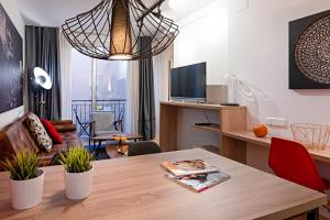 una sala de estar con mesa y una habitación con TV en Habitat Apartments Hot Jazz, en Barcelona