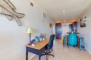 Habitación con escritorio, mesa y sillas. en The Dawn Condominiums, en Galveston