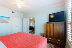 a bedroom with a bed and a flat screen tv at The Dawn Condominiums in Galveston