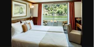 a bedroom with a large bed and a window at Douro Cruiser in Vila Nova de Gaia