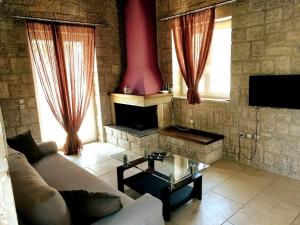 een woonkamer met een bank en een open haard bij Villa *Orizontas*/5' from town-sea/Mountain view in Lefkada