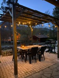 een houten pergola met een tafel en stoelen op een patio bij Maison agréable et familliale in Roquefort-les-Pins