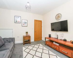 a living room with a couch and a flat screen tv at No25-Luxe Living Guest House- 2 Bed-WIFI-Free Parking-City- Beach in Swansea