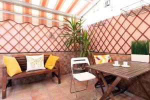 een patio met een houten tafel en bank en een tafel en stoelen bij Terrace at 20 minutes from Duomo - HomeUnity in Milaan