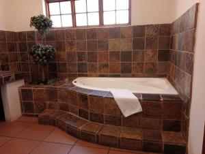 uma casa de banho com uma banheira com uma toalha em Kuruman Hotel em Kuruman