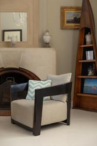 a chair in a living room with a fireplace at Villa Les Délices in Cap-Ferret