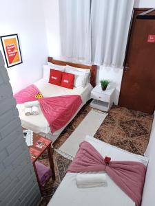 Duas camas num quarto com almofadas vermelhas em Pousada Torre dos Mouros em Pirenópolis